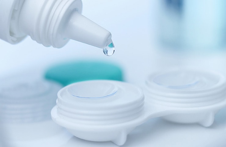 Contacts solution being dropped into a contact lens case